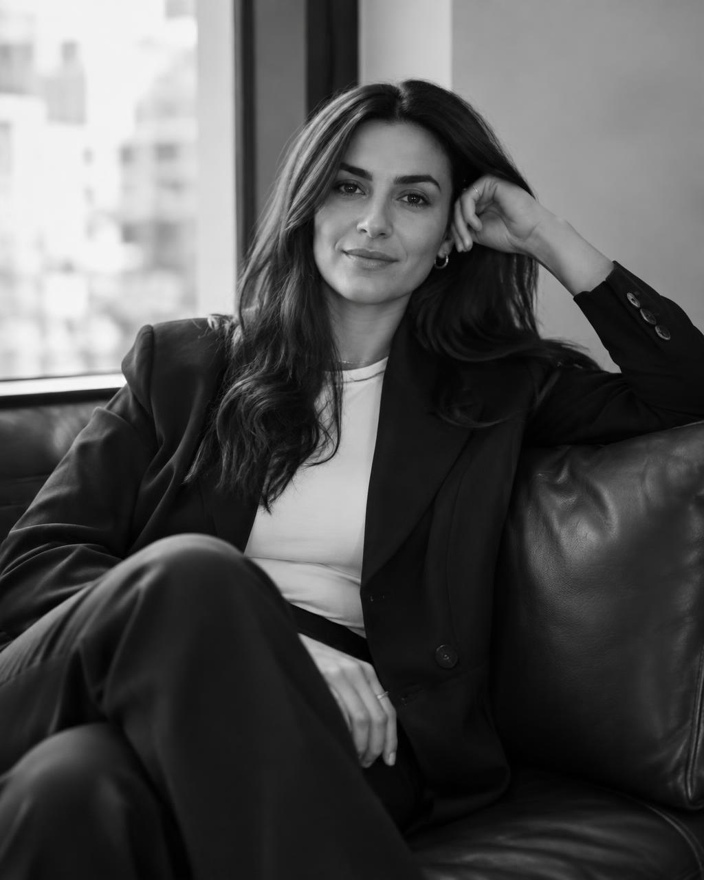 Founder seated on a leather sofa, black and white portrait